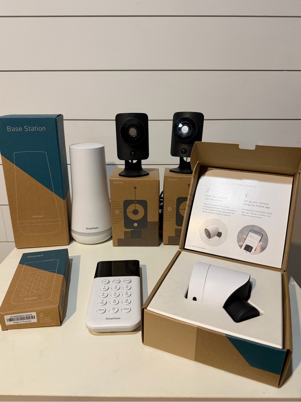SimpliSafe white and black security camera kit with base station